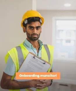 Muncitor din Asia cu cască și vestă reflectorizantă, ținând un clipboard în prima zi la locul de muncă